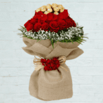 Combination of Red Roses, Ferraro Rocher Chocolate, Gypsophila, Palm Leaf with Seasonal Greenery from JuneFlowers.com